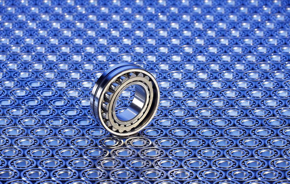 Ein einzelnes Kugellager steht auf einer Hintergrundoberfläche, die mit vielen weiteren kleinen Kugellagern in einem gleichmäßigen Muster bedeckt ist. Die Oberflächen sind metallisch und reflektieren das Licht, wodurch eine technische und präzise Anmutung entsteht.