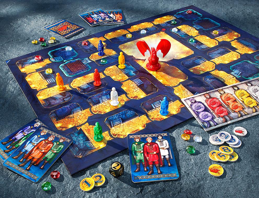 Brettspielauflage mit einem bunten Spielbrett, Figuren in verschiedenen Farben, einem roten Drachen und Spielkarten. Verschiedene Spielsteine und Chips liegen um das Brett verteilt, während Charakterkarten in der Nähe liegen.